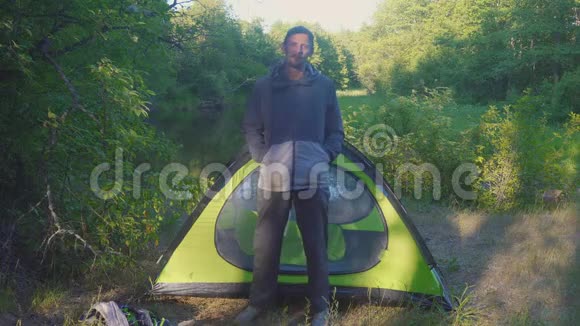 4k夏天森林里一个人站在河边的帐篷附近视频的预览图