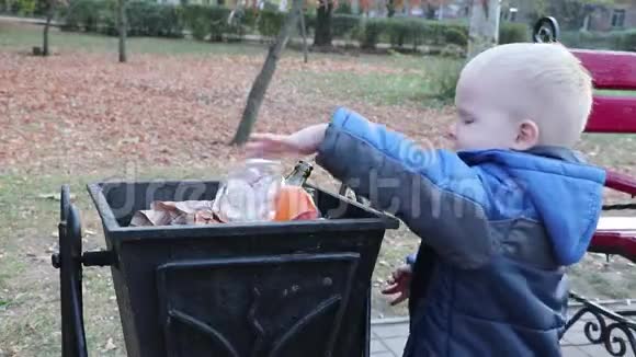一个小男孩在街上的垃圾桶里扔垃圾废物管理和环境保护的理念适当的做法视频的预览图