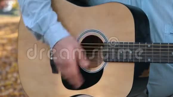 在户外弹声吉他的人的特写手指视频的预览图