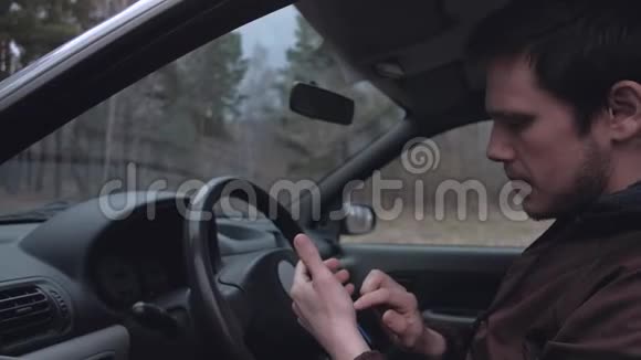 欧洲男人使用智能手机坐在车里视频的预览图