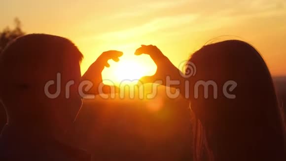 日落时分的浪漫情侣从手中展现出一种心形视频的预览图