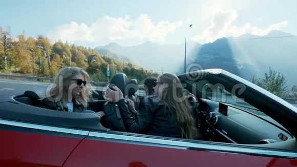 迷人的欧洲女性朋友在高山上唱歌跳舞鼓掌驾驶豪华敞篷汽车视频的预览图