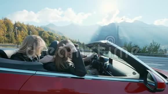 迷人的欧洲女性朋友在高山上唱歌跳舞鼓掌驾驶豪华敞篷汽车视频的预览图