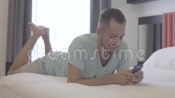 男人用智能手机写信息躺在床上视频的预览图