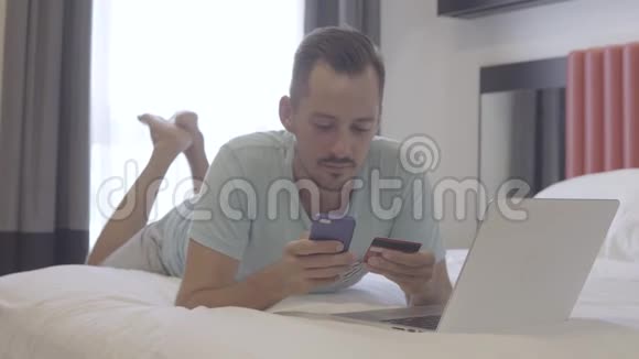 男人用智能手机在线银行躺在床上视频的预览图