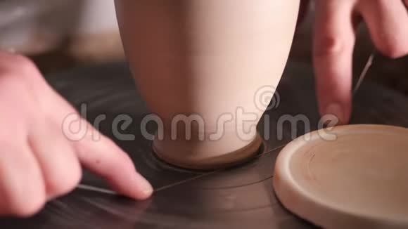 波特大师从陶罐中取出成品借助陶工车轮上的螺纹为它做准备视频的预览图