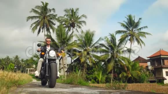 高加索人在热带停车摩托车的肖像视频的预览图