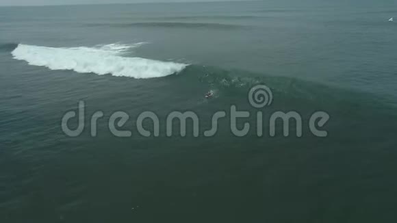 巴厘岛一个女人在海洋冲浪极限水上运动的空中镜头视频的预览图