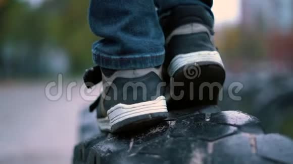 游乐场关门男孩运动鞋在汽车上行走时轮胎慢动作视频的预览图