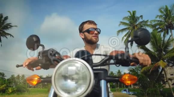 年轻快乐的白种人坐在摩托车上视频的预览图