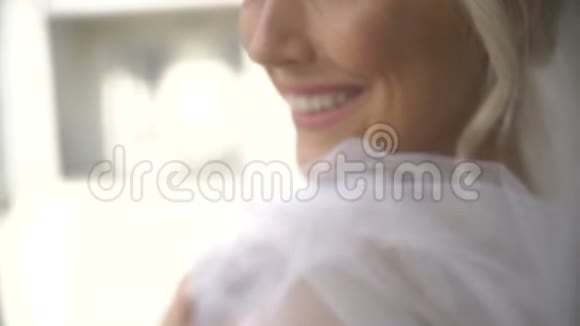 这位戴着面纱的美丽新娘的特写侧面肖像配上迷人的妆容对着镜头微笑视频的预览图