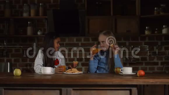 孩子们在厨房里吃饼干和喝果汁视频的预览图