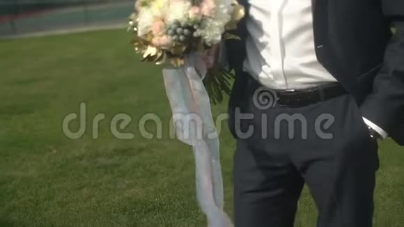 上下移动摄像机穿着豪华西装戴着太阳镜的时尚新郎举行婚礼的外观概述视频的预览图