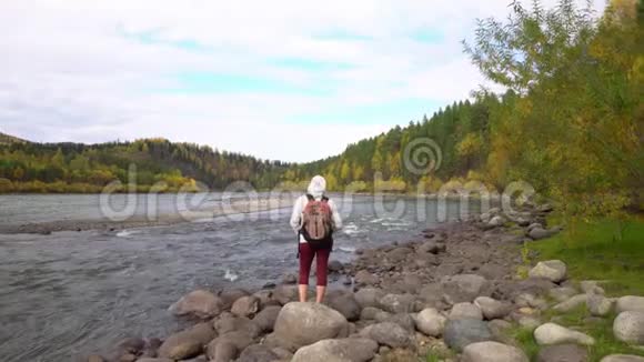 旅行者的女人在山河岸上花钱堕落视频的预览图
