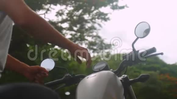 坐在摩托车上的白衣男子视频的预览图