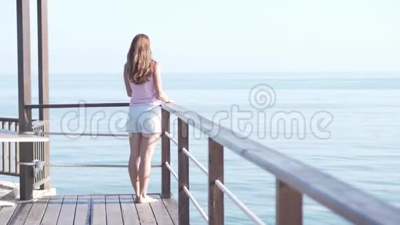 一个穿短裤的女人站在木桥边上视频的预览图