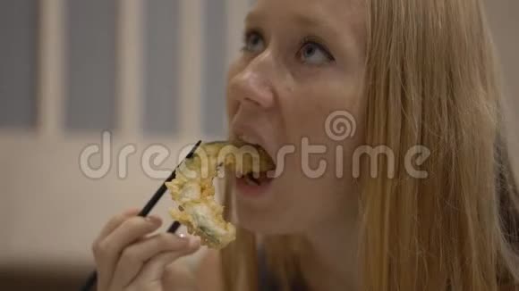 一个年轻女子在餐馆里吃日本菜的慢镜头视频的预览图