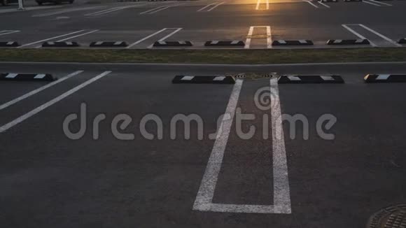 在黄金时间日落时分在购物中心一片空旷的停车场以80慢动作拍摄视频的预览图