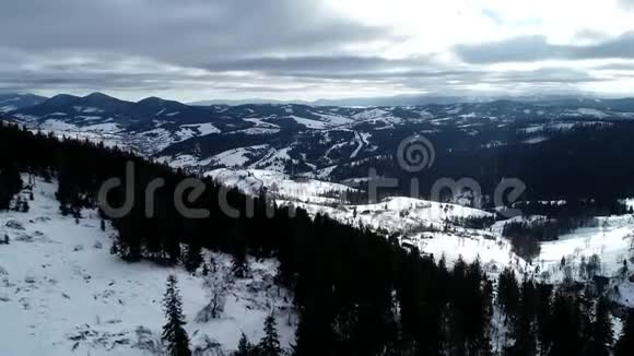 空气视图冬季山区的乡村景观从鸟瞰森林中白雪覆盖房屋视频的预览图