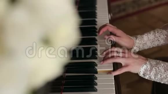 一位温柔甜美的新娘弹钢琴的特写视频的预览图