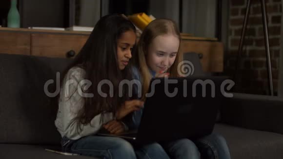 快乐的女朋友在笔记本电脑上看动画片视频的预览图