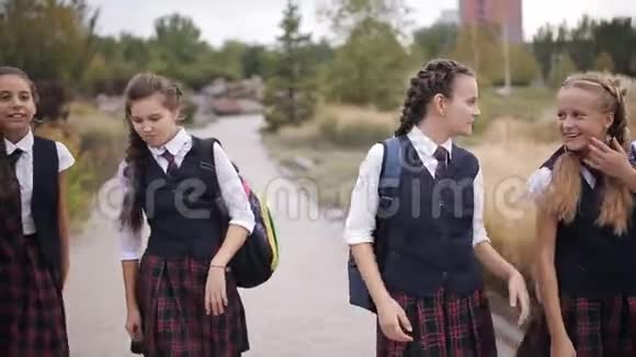 穿着同样校服的女学生背着背包在公园里嬉笑打闹视频的预览图