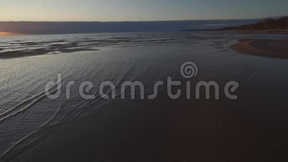 深红的日落晴朗的天空和镜子如水中的倒影带肋的沙子和波浪图亚拉脱维亚4月13日视频的预览图