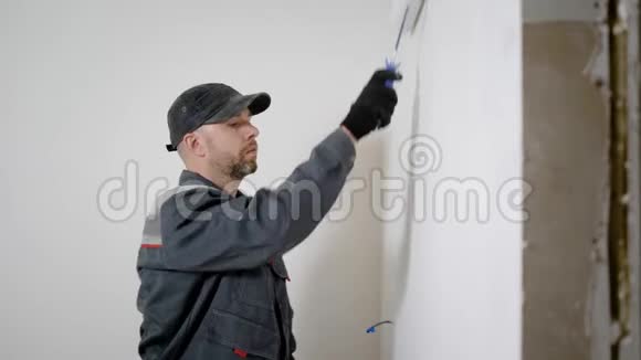 有经验的工人正在房子里做装修他正在用滚筒来装饰前墙视频的预览图