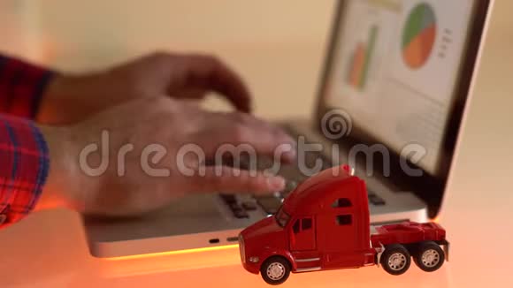 笔记本电脑键盘上一辆红色小玩具卡车的特写镜头视频的预览图
