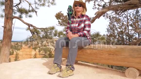 女游客在峡谷休息坐在木凳上在一个远足小径4K视频的预览图
