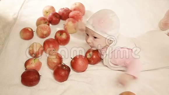 一个婴儿和一个苹果光背景上的孩子快乐的孩子视频的预览图