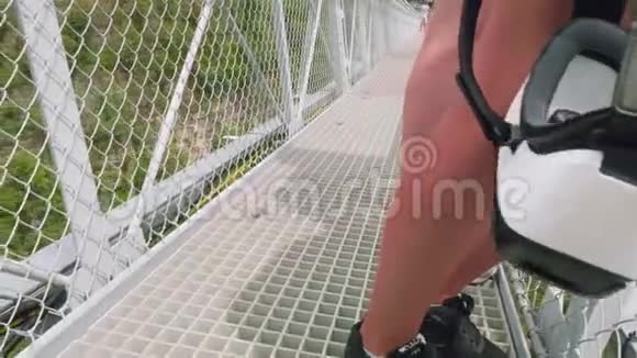 近景白种人的女性腿站在悬索桥上的树林青山开始运动视频的预览图