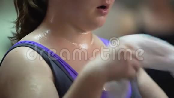 出汗的妇女在健身房锻炼后休息接受减肥训练视频的预览图