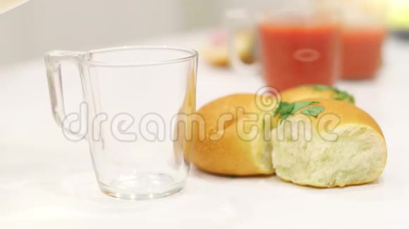 牛奶倒在白桌子上的玻璃杯里视频的预览图
