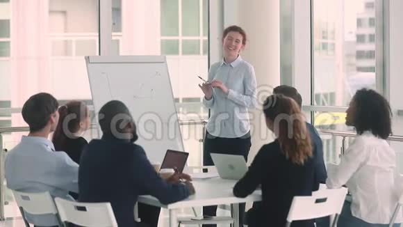 不同的员工和女教练在商业培训中举手视频的预览图