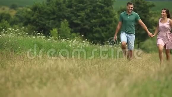 男人和女人一起在田野里奔跑浪漫的气氛慢动作视频的预览图