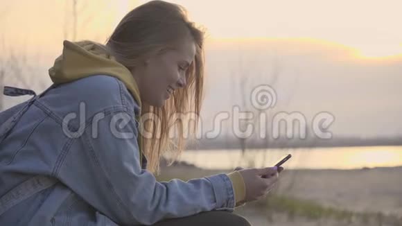 日落海滩和女孩用智能手机聊天视频的预览图