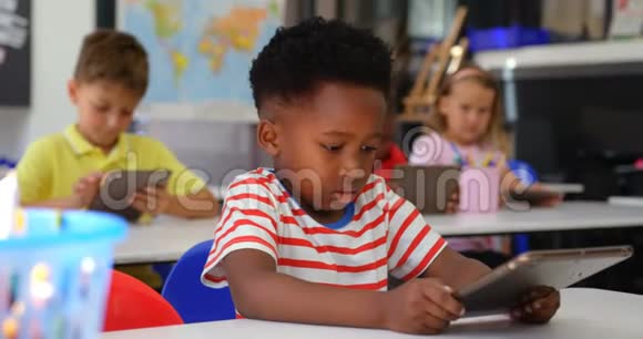 非裔美国小学生在4k教室中使用数字平板电脑的正面图视频的预览图
