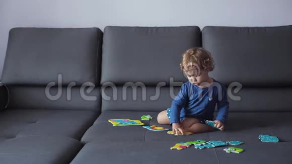 金发卷曲的小女孩玩益智玩具蓝色的衣服感到高兴视频的预览图