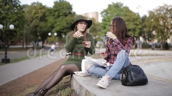 两个与众不同的女人在街上吃三明治和薯条视频的预览图
