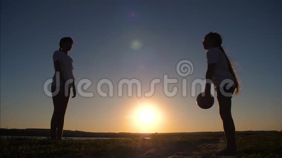 女孩青少年在日落时打球慢动作视频的预览图