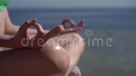 海洋海滩上练习瑜伽的特写镜头视频的预览图