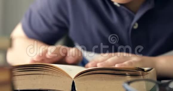 密切亚洲男孩阅读一本书的手视频的预览图