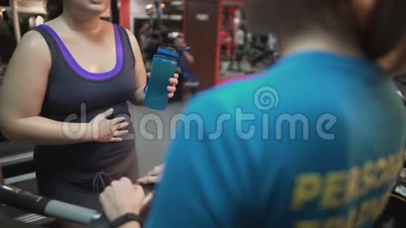 孕妇与私人教练协商在健身房进行孕期锻炼视频的预览图