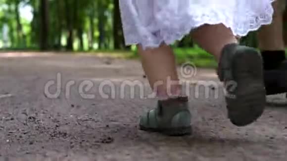 孩子们脚穿凉鞋穿过公园关门视频的预览图