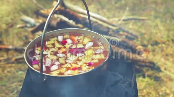 一个女人手盖着一个碗汤盖站在火上视频的预览图