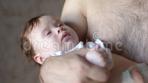 婴儿躺在父亲的怀里微笑着视频的预览图