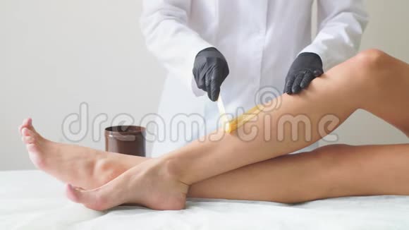 女保健腿脱毛专业工作特写在工作室做的女性身体部位的硬温蜡视频的预览图