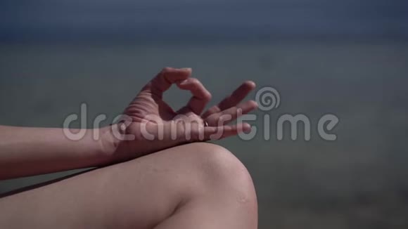 海洋海滩上练习瑜伽的特写镜头视频的预览图