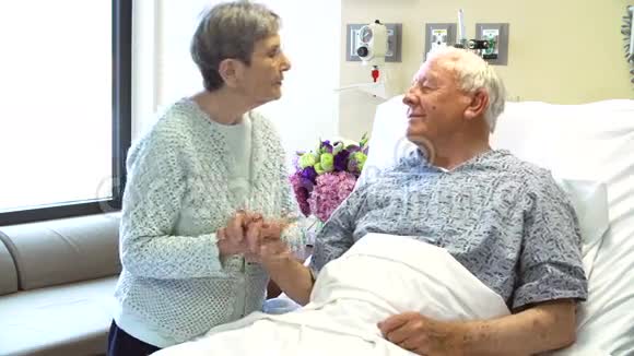 高级妇女探访丈夫在医院病房视频的预览图